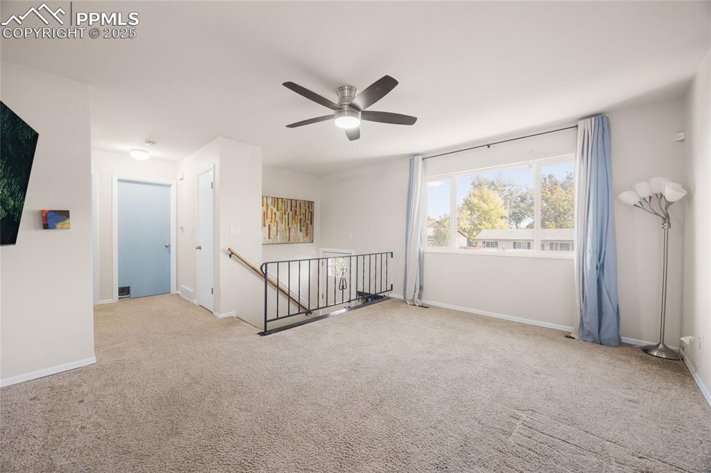 Image 2 of 15: Empty room featuring light colored carpet and a ceiling fan