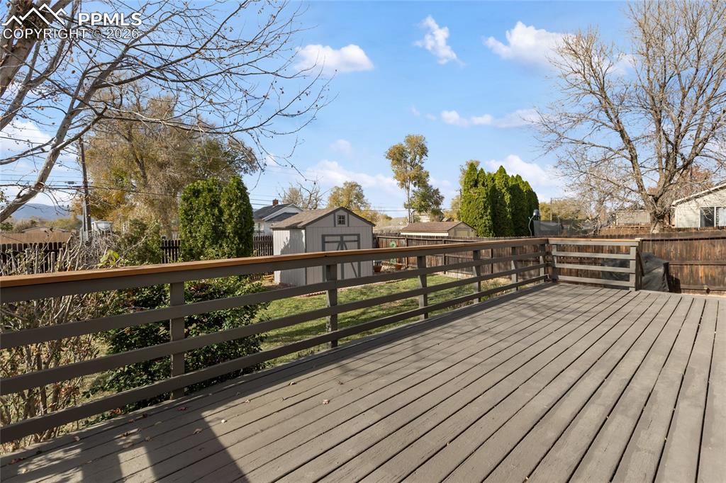Image 37 of 37: Deck with a storage unit and a fenced backyard
