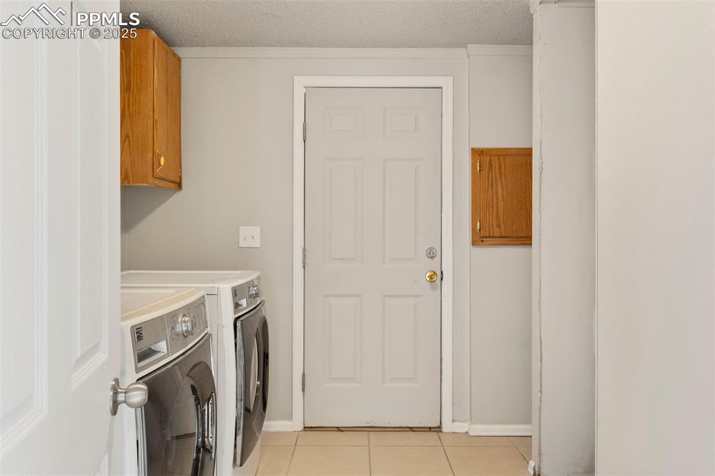 Image 17 of 34: Washroom featuring independent washer and dryer, light tile patterned floor