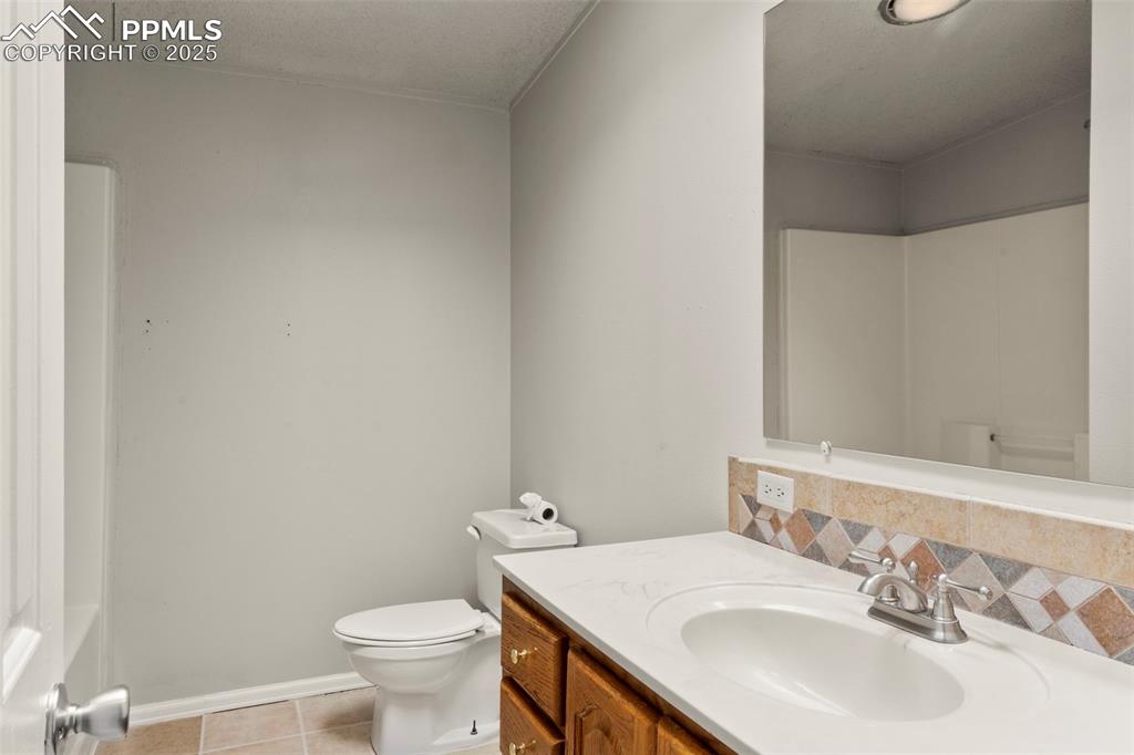 Image 19 of 34: Bathroom with vanity, tile patterned flooring, and decorative backsplash