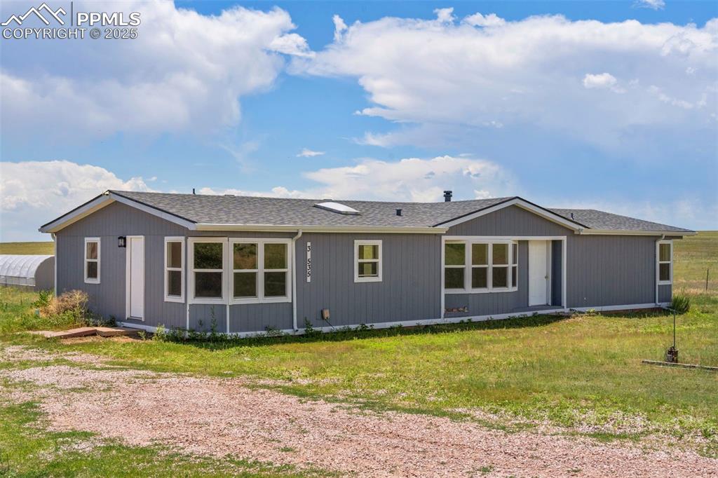 Image 2 of 34: Rear view of property with a lawn and roof with shingles