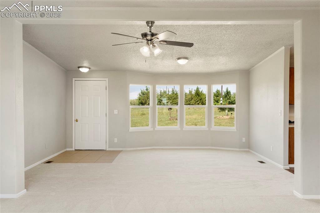 Image 4 of 34: Carpeted spare room featuring ceiling fan and baseboards