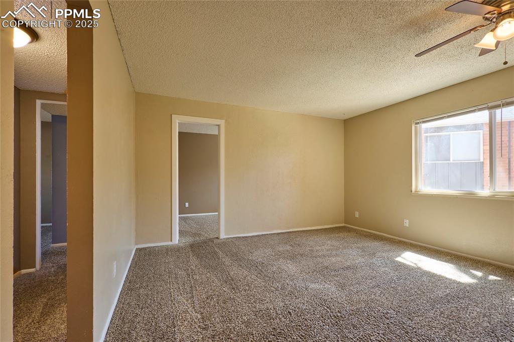 Image 8 of 24: Unfurnished room featuring baseboards, a ceiling fan, a textured ceiling, a