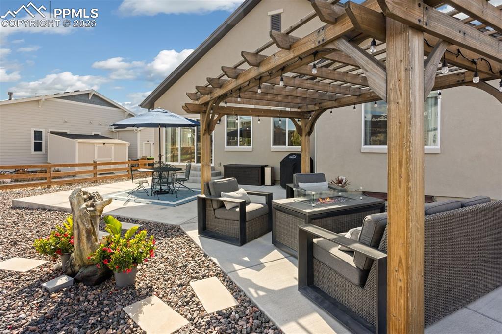 Image 31 of 41: Enlarged back patio with 2 separate sitting areas and pergola