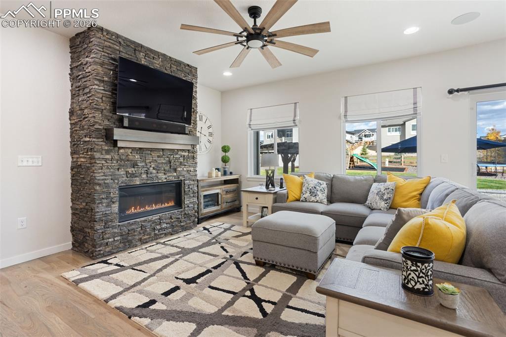 Image 8 of 41: Main level living room with liner gas fireplace and floor to ceiling stone