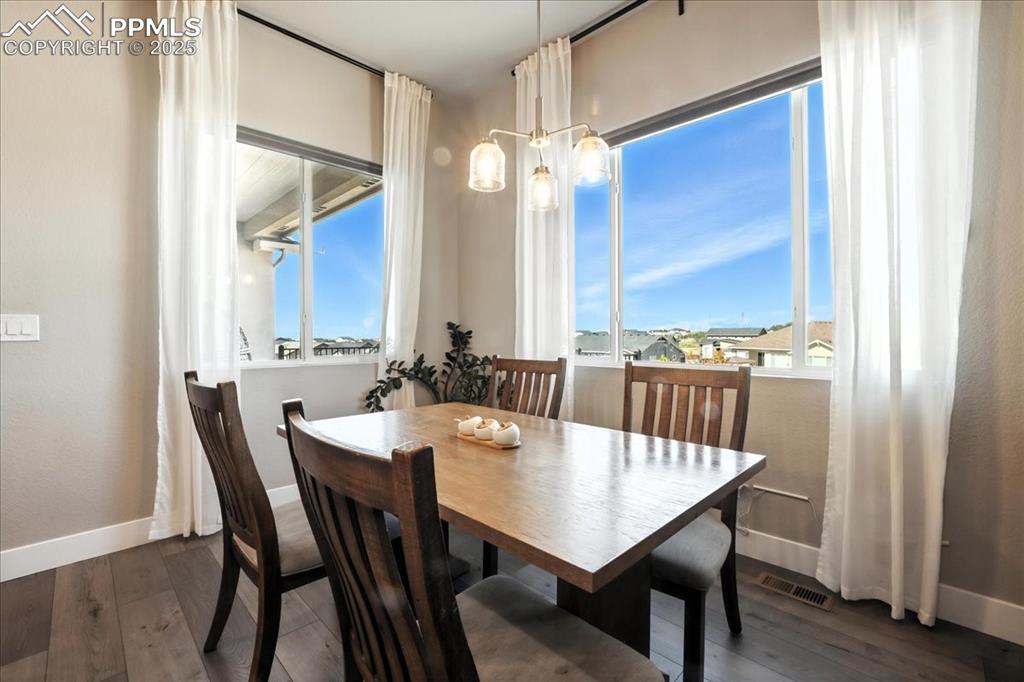 Image 11 of 50: Dining room with wood finished floors and a chandelier