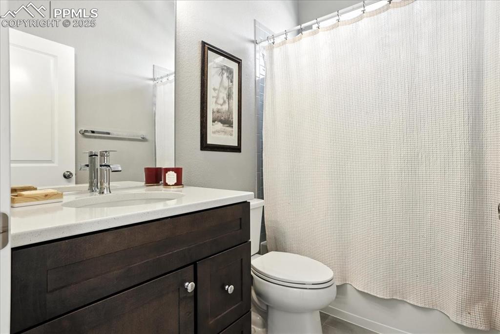 Image 14 of 50: Bathroom with vanity and shower / bathtub combination with curtain