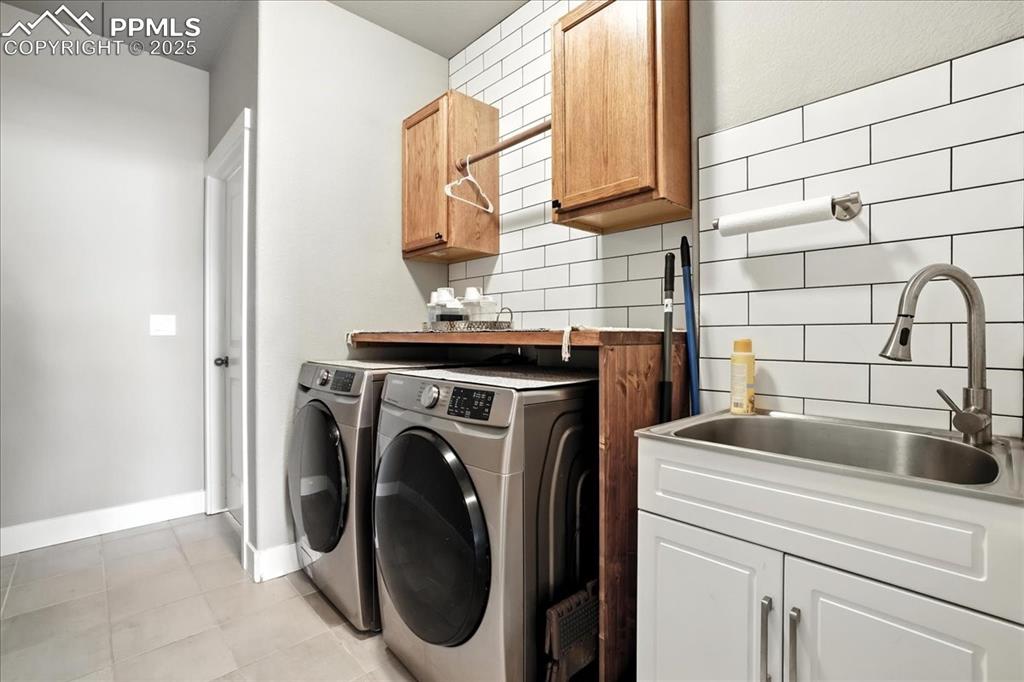 Image 15 of 50: Laundry room with cabinet space, independent washer and dryer, and light ti