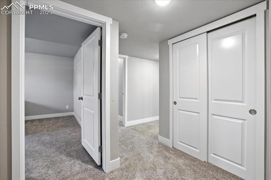 Image 27 of 50: Hall featuring carpet floors and a textured ceiling
