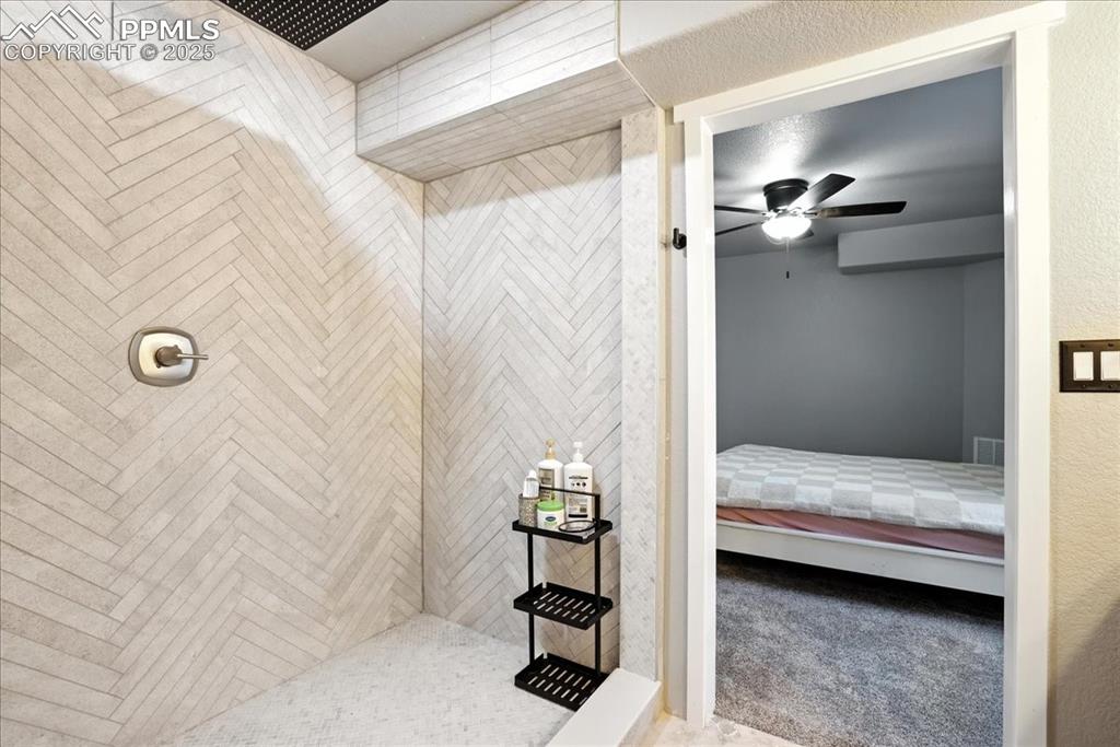 Image 32 of 50: Full bathroom featuring ensuite bath, tiled shower, and a ceiling fan