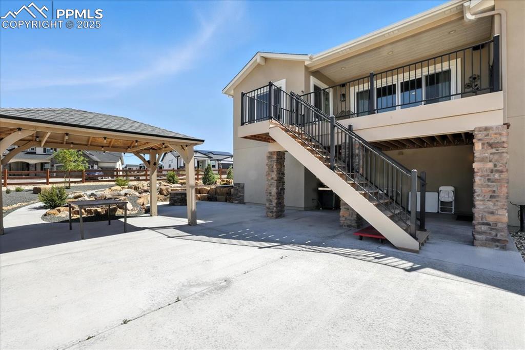 Image 33 of 50: View of patio with stairs and a gazebo