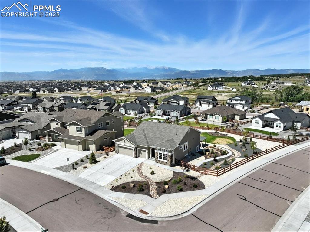 Image 44 of 50: Aerial view of residential area featuring a mountain backdrop
