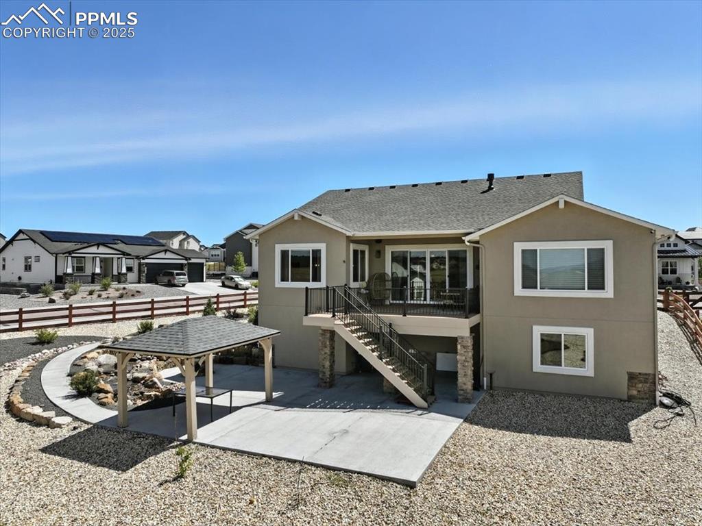 Image 46 of 50: Back of property with a patio, stucco siding, a residential view, and a shi