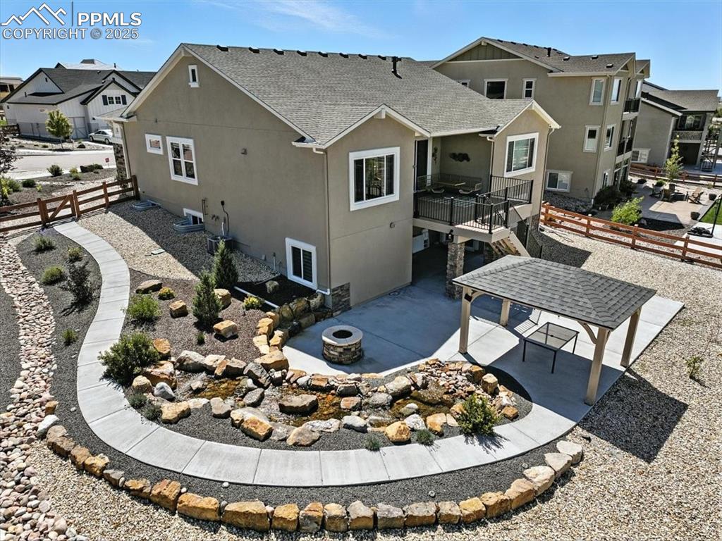 Image 47 of 50: Back of property featuring a fire pit, a residential view, stucco siding, a