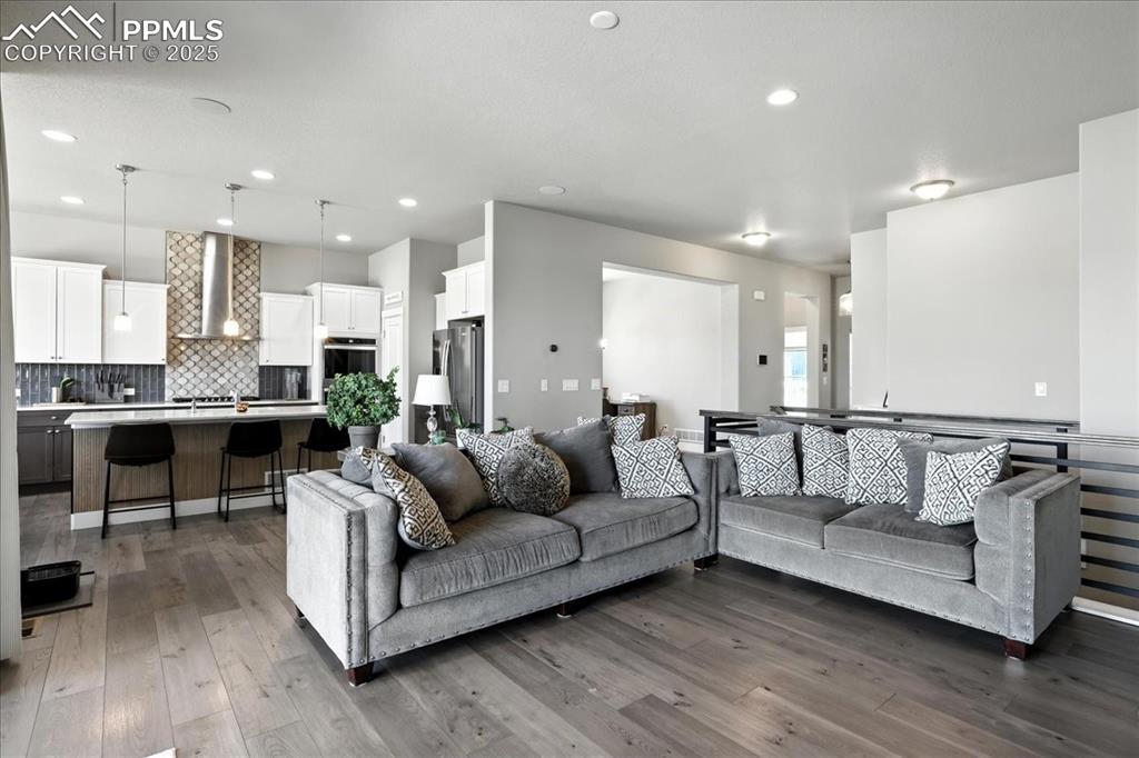 Image 9 of 50: Living room featuring wood finished floors and recessed lighting