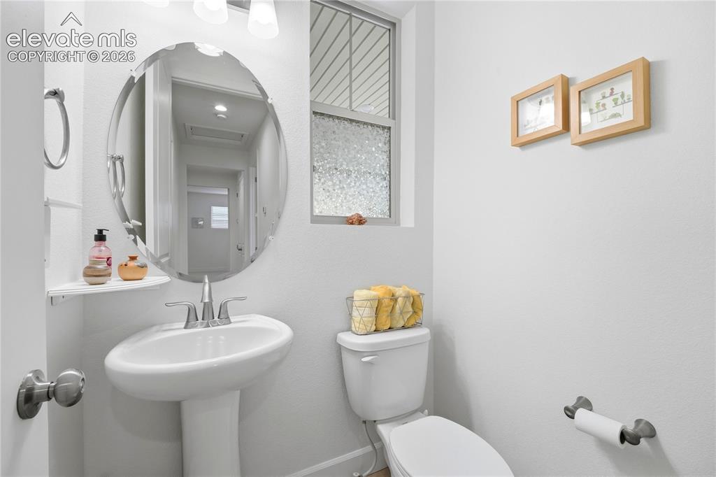 Image 21 of 50: Guest bath Pedestal sink with a polished chrome faucet, an oval mirror with