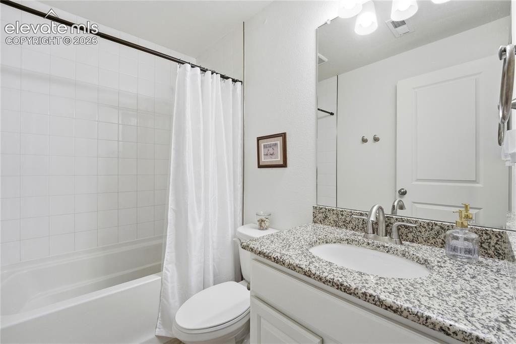 Image 35 of 50: Full basement bathroom featuring a vanity with a granite-style countertop, 