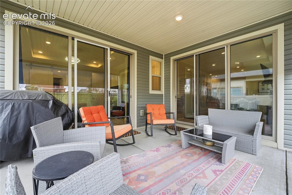 Image 4 of 50: Covered back patio featuring multiple sliding glass doors, recessed lightin