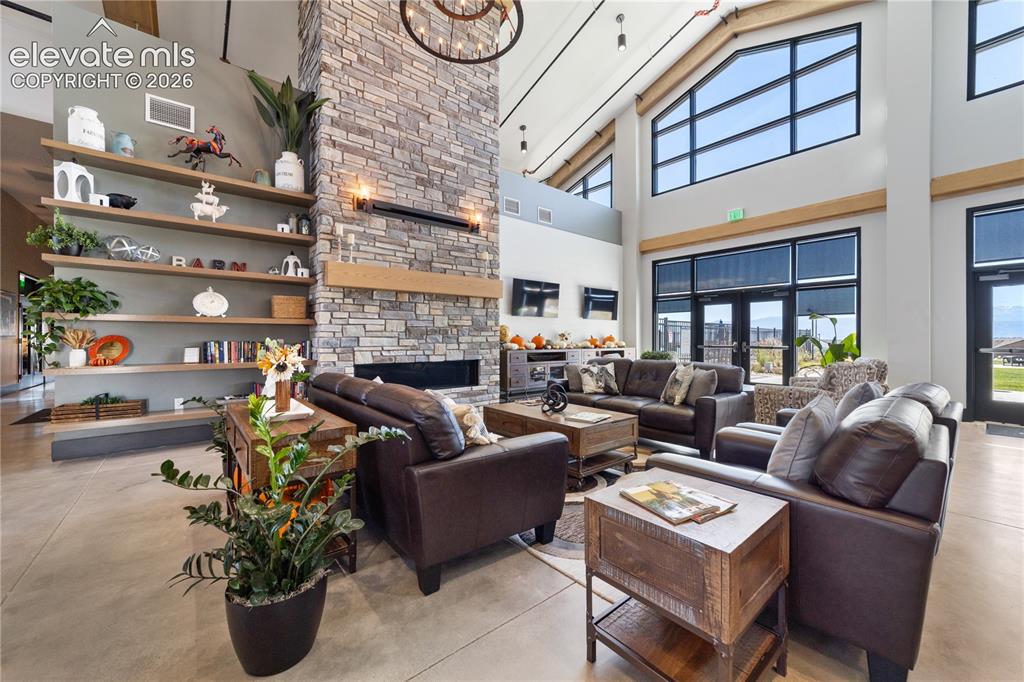 Image 40 of 50: Common area featuring a floor-to-ceiling stone fireplace, high vaulted ceil