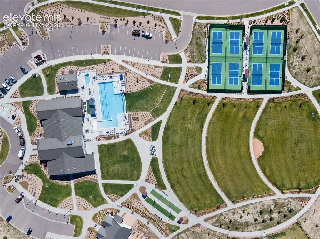 Image 49 of 50: Community amenities featuring a central clubhouse, an outdoor swimming pool
