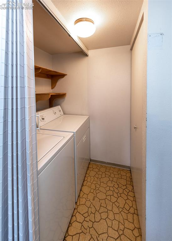 Image 20 of 40: Laundry room featuring washer and dryer and a textured ceiling