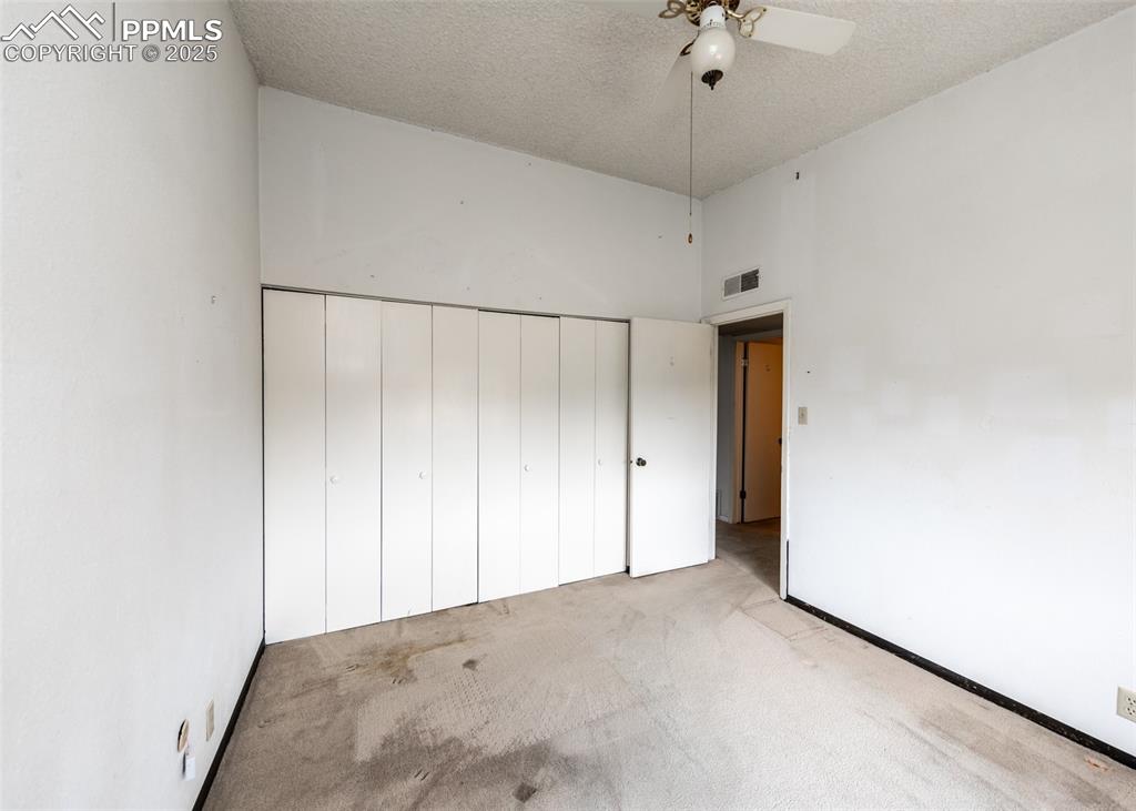 Image 29 of 40: Unfurnished bedroom with carpet floors, a textured ceiling, a closet, a hig