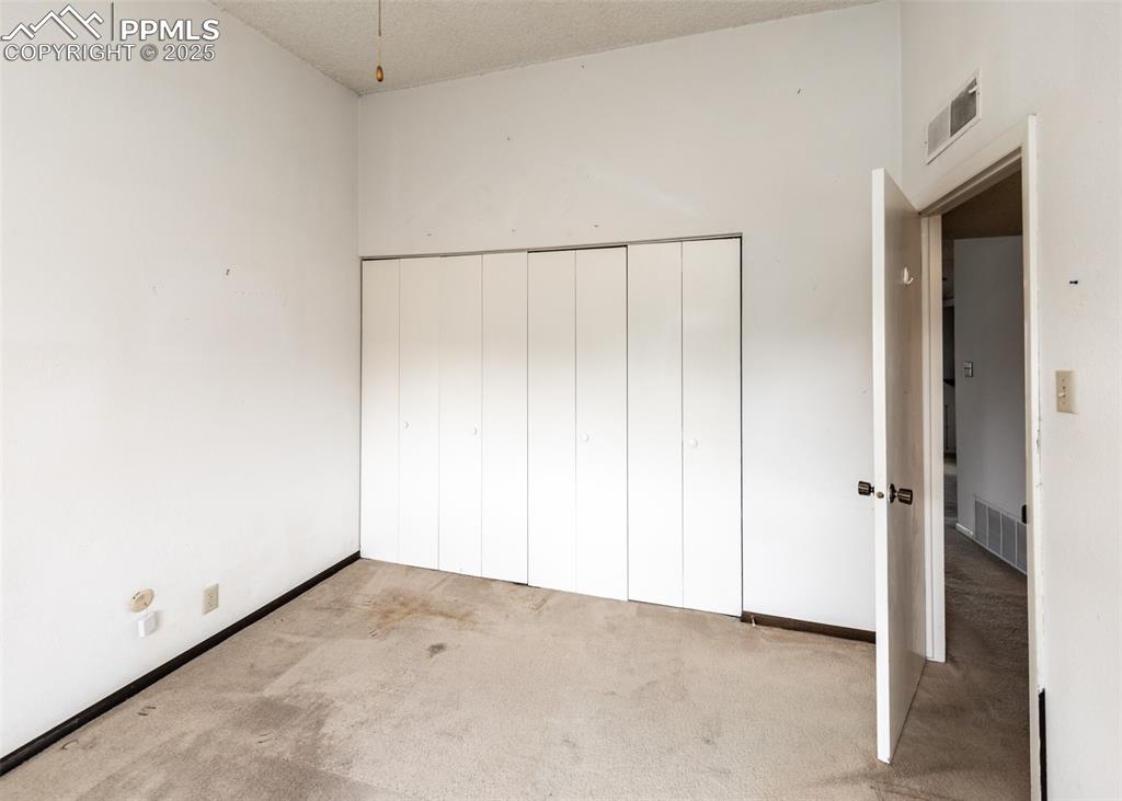 Image 30 of 40: Unfurnished bedroom with carpet and a closet