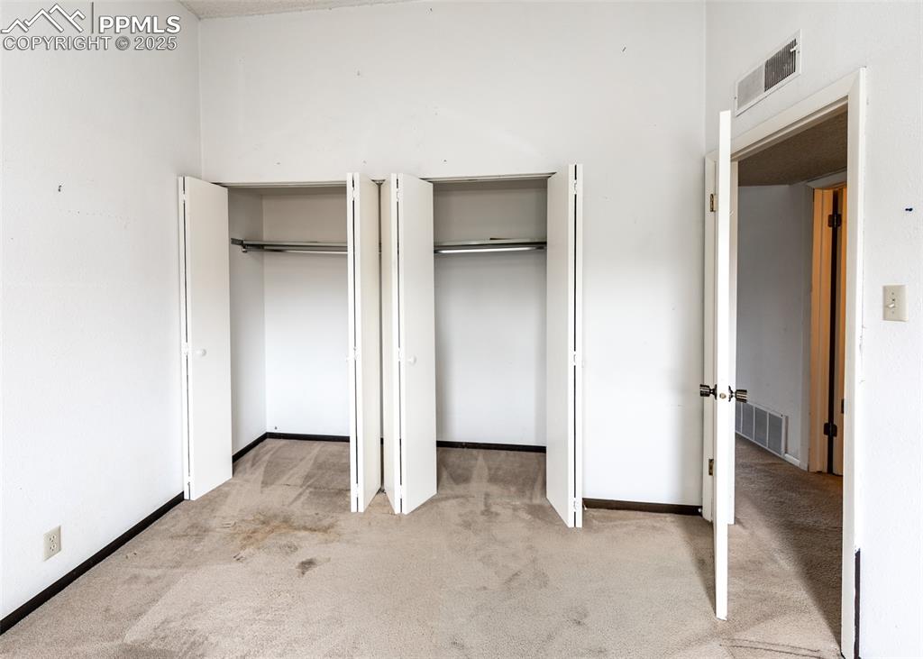 Image 31 of 40: Unfurnished bedroom featuring light carpet and two closets