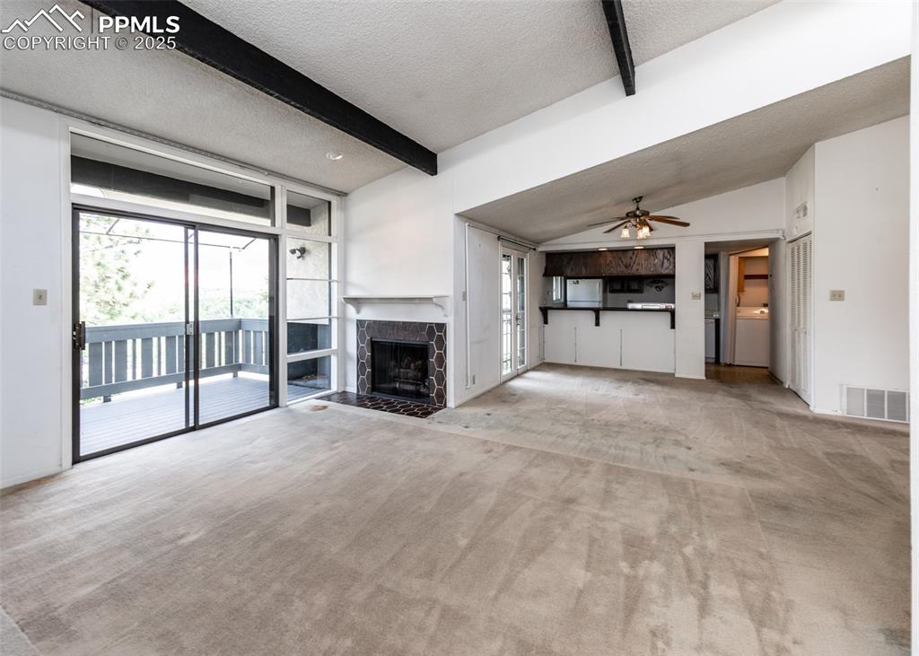 Image 8 of 40: Unfurnished living room with a textured ceiling, ceiling fan, light colored