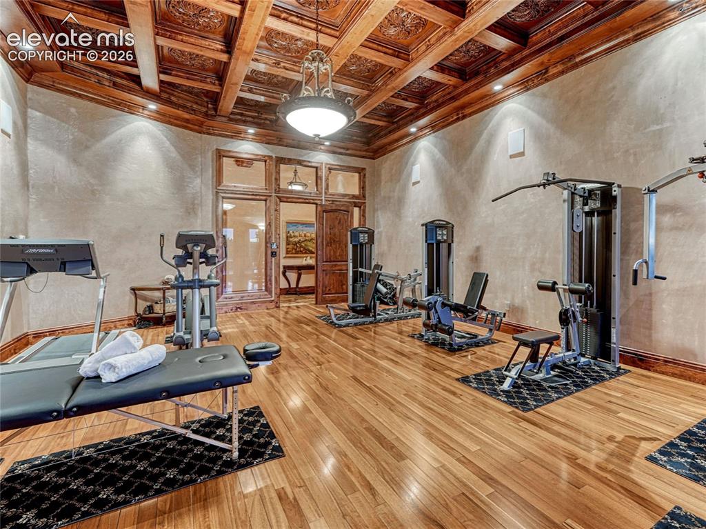Image 34 of 50: Fitness room w/outdoor access and hardwood flooring.