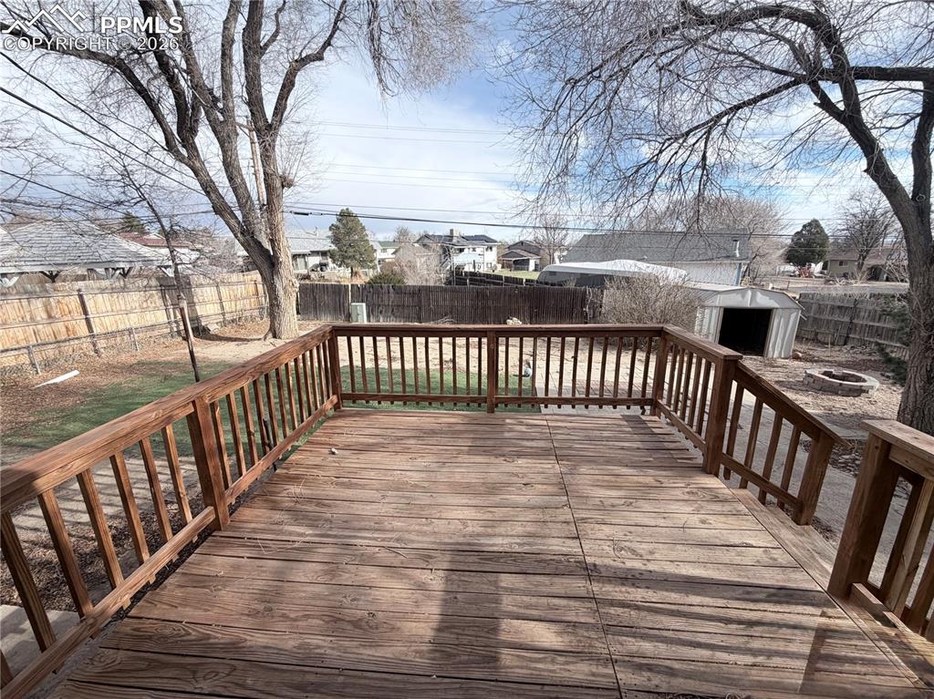Image 12 of 15: Wooden deck with a fenced backyard, a residential view, an outdoor fire pit