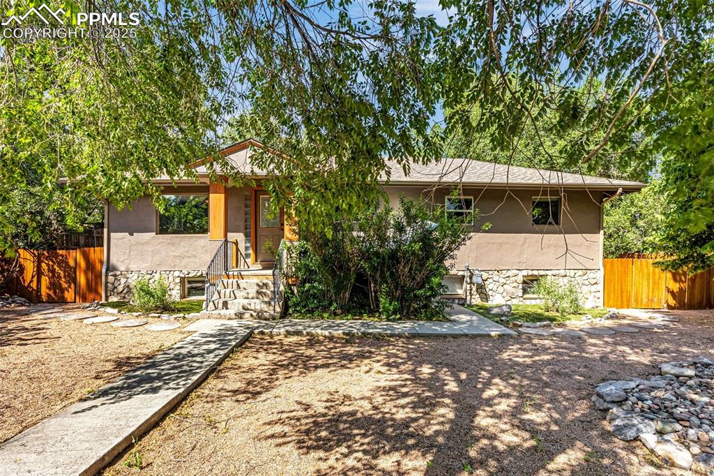 Caption: View of front of home with stone siding and stucco siding