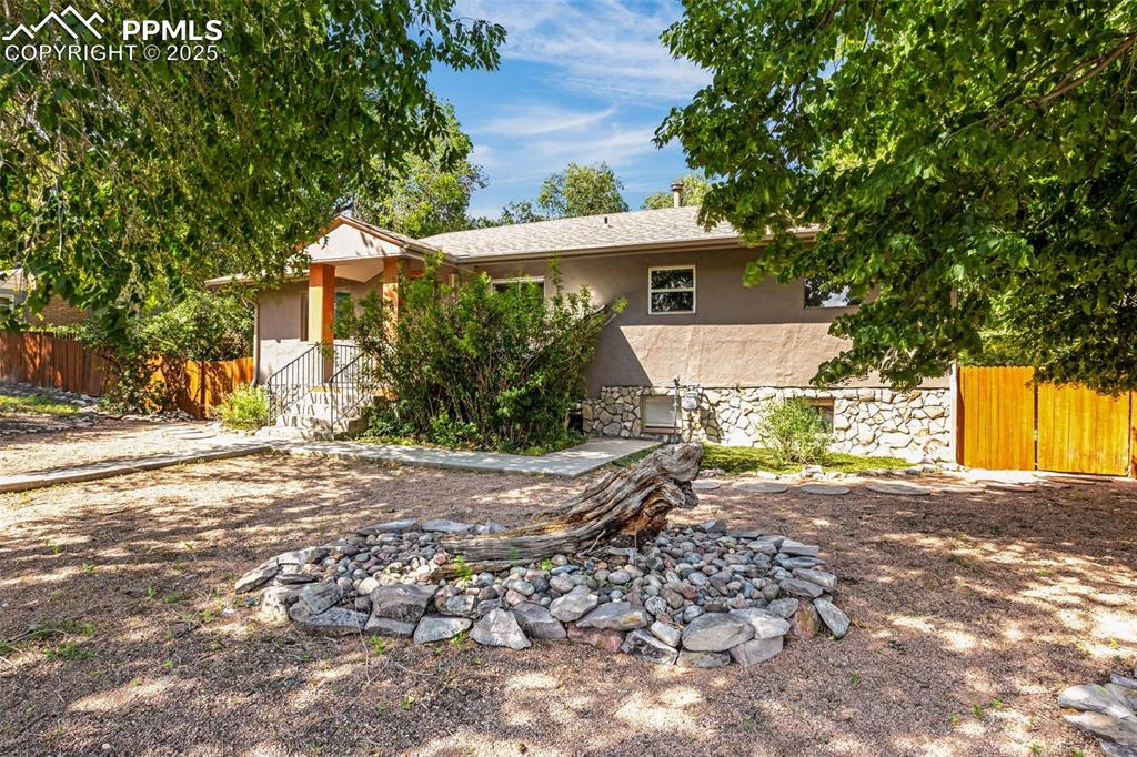 Image 2 of 42: Rear view of house with stucco siding and stone siding