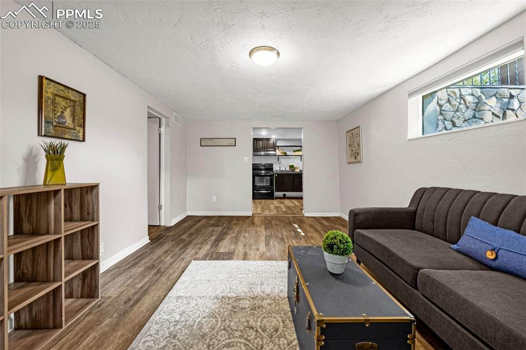 Image 25 of 42: Living area with wood finished floors and a textured ceiling
