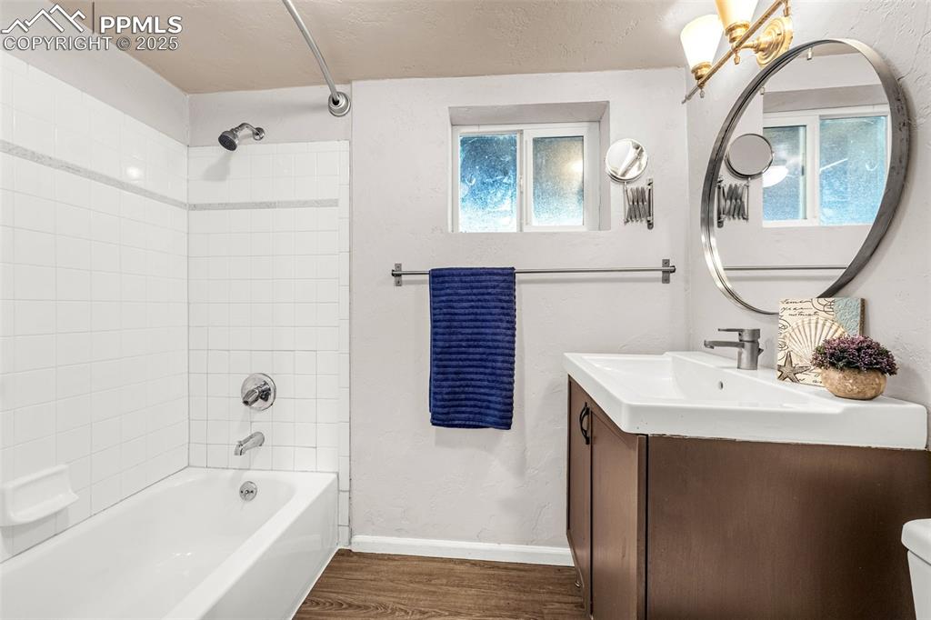 Image 29 of 42: Full bath with wood finished floors, vanity, and tub / shower combination