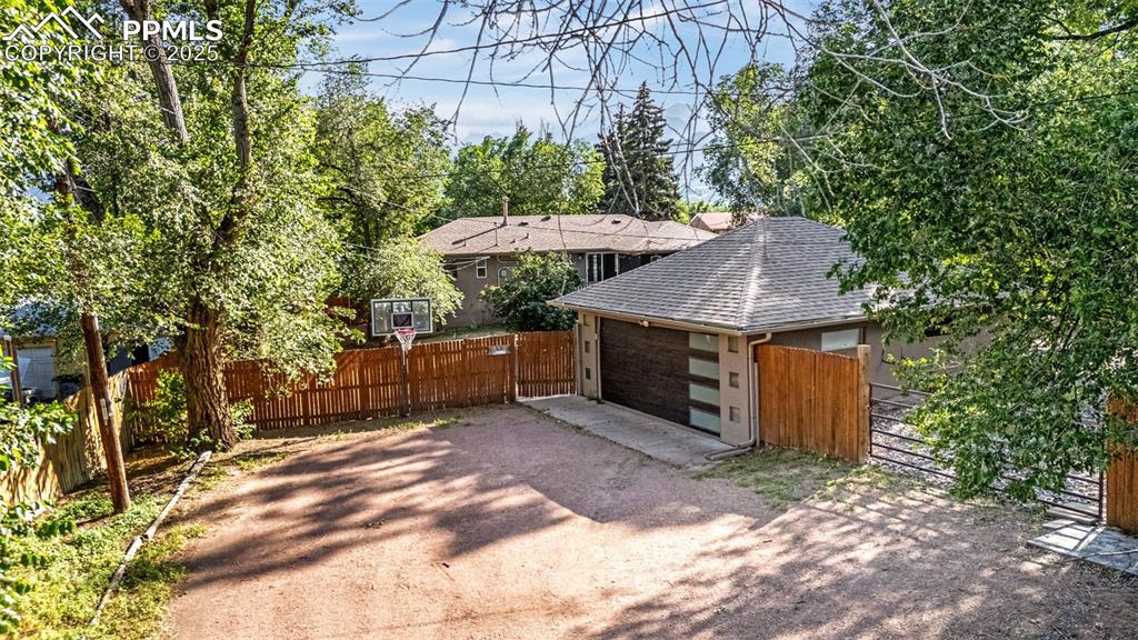 Image 4 of 42: Garage featuring dirt driveway and a gate
