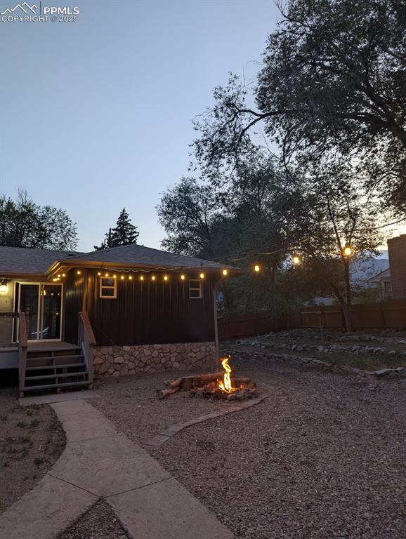 Image 42 of 42: Yard at dusk with a fire pit and stairway