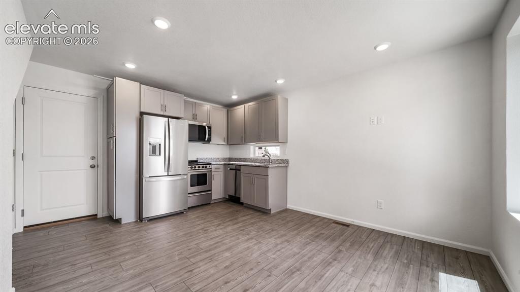 Image 12 of 17: Kitchen featuring stainless steel appliances, wood-finish flooring, recesse