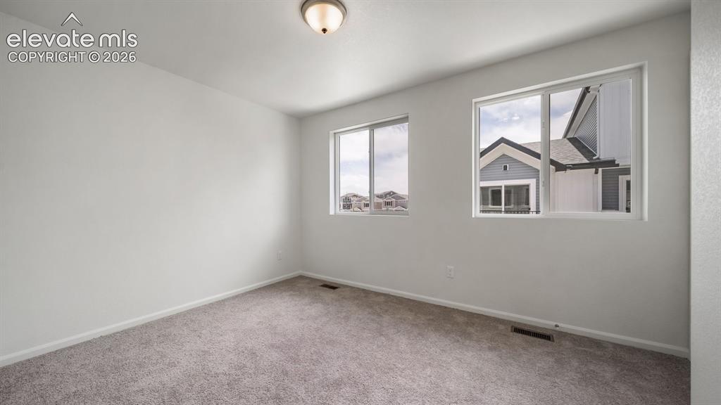 Image 3 of 17: Wall-to-wall carpeting with a neutral finish, white painted walls, two larg