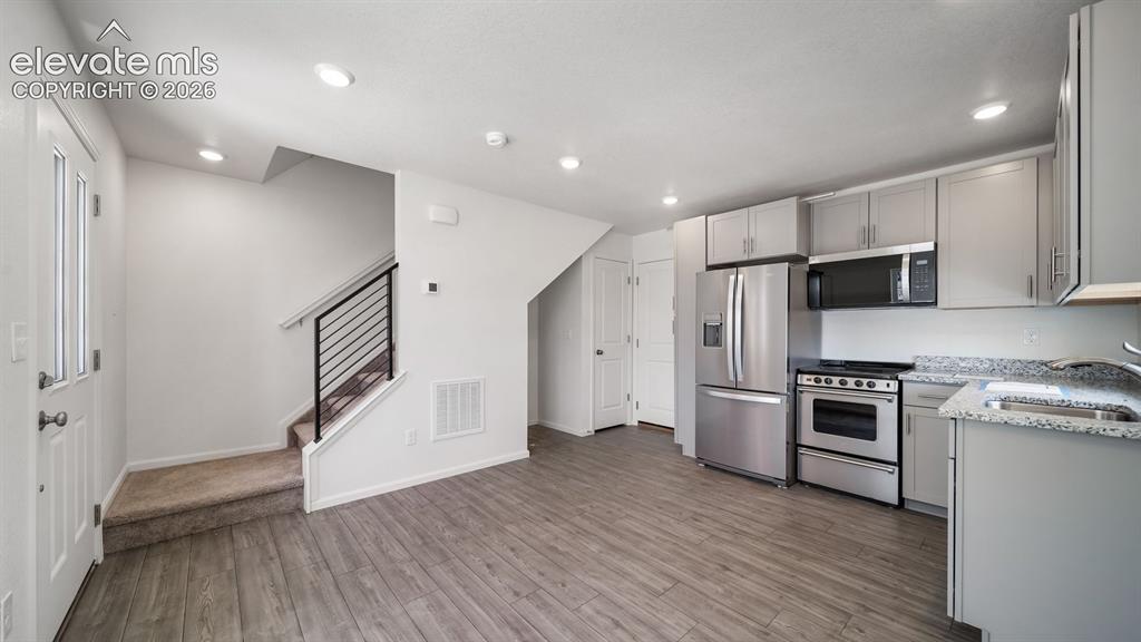 Image 9 of 17: Stainless steel appliances, wood-finish flooring, recessed lighting, light