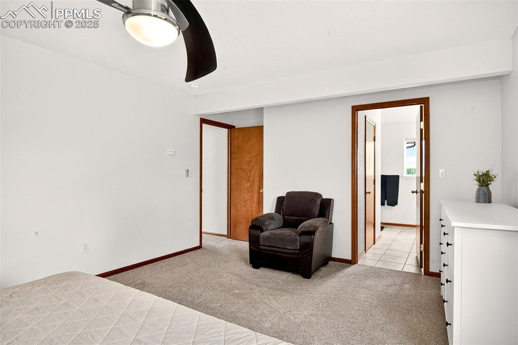 Image 14 of 40: Bedroom featuring light carpet, a ceiling fan, and generous sitting area