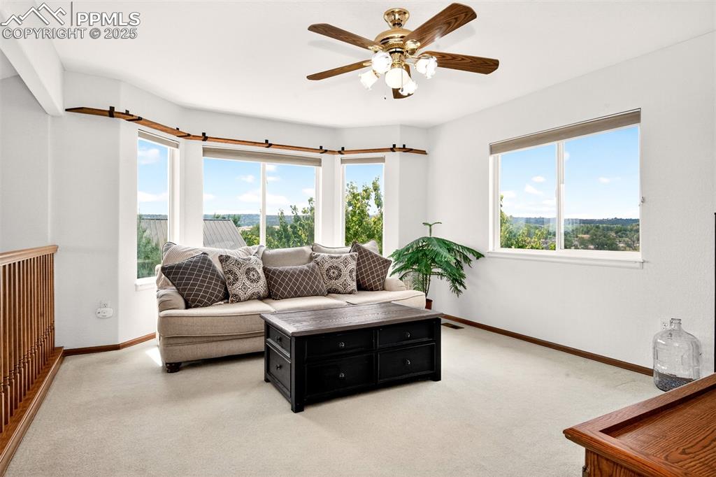 Image 18 of 40: Upstairs loft with light carpet, plenty of natural light, and a ceiling fan