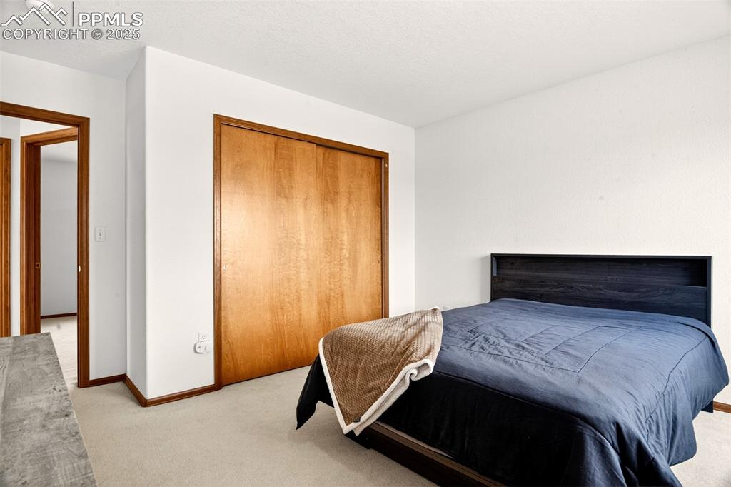 Image 20 of 40: Upper level bedroom with carpet, a large window and a closet