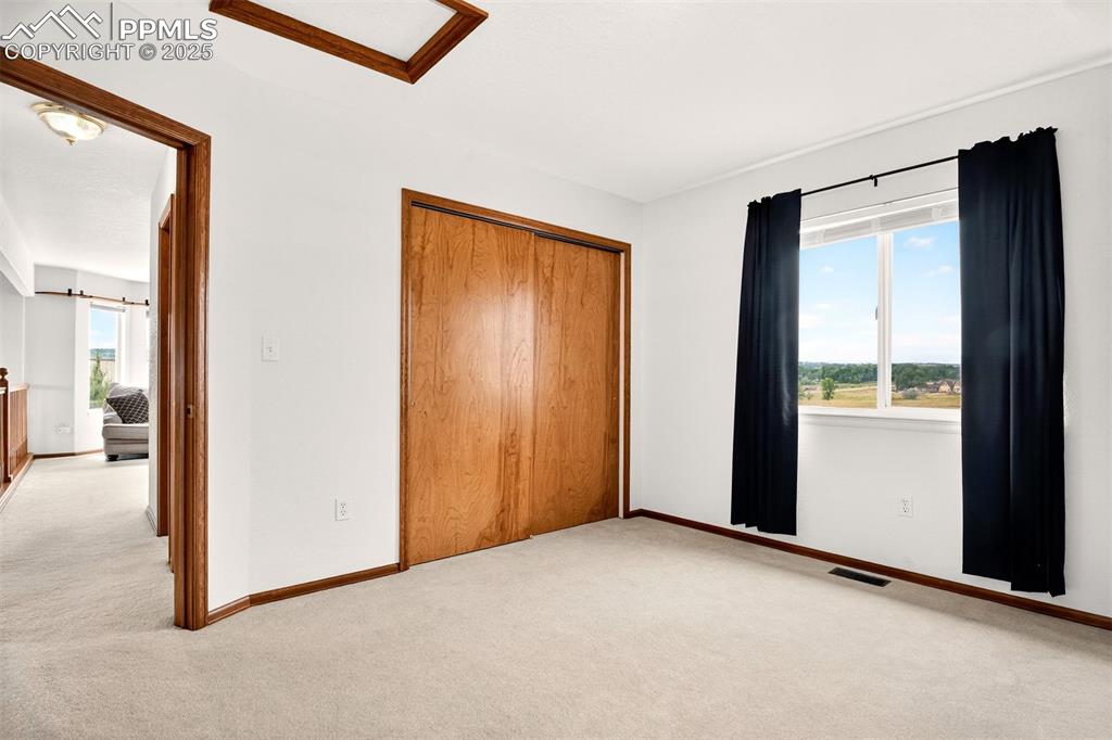 Image 22 of 40: Upper level bedroom with a closet, carpet flooring, and attic access - exce
