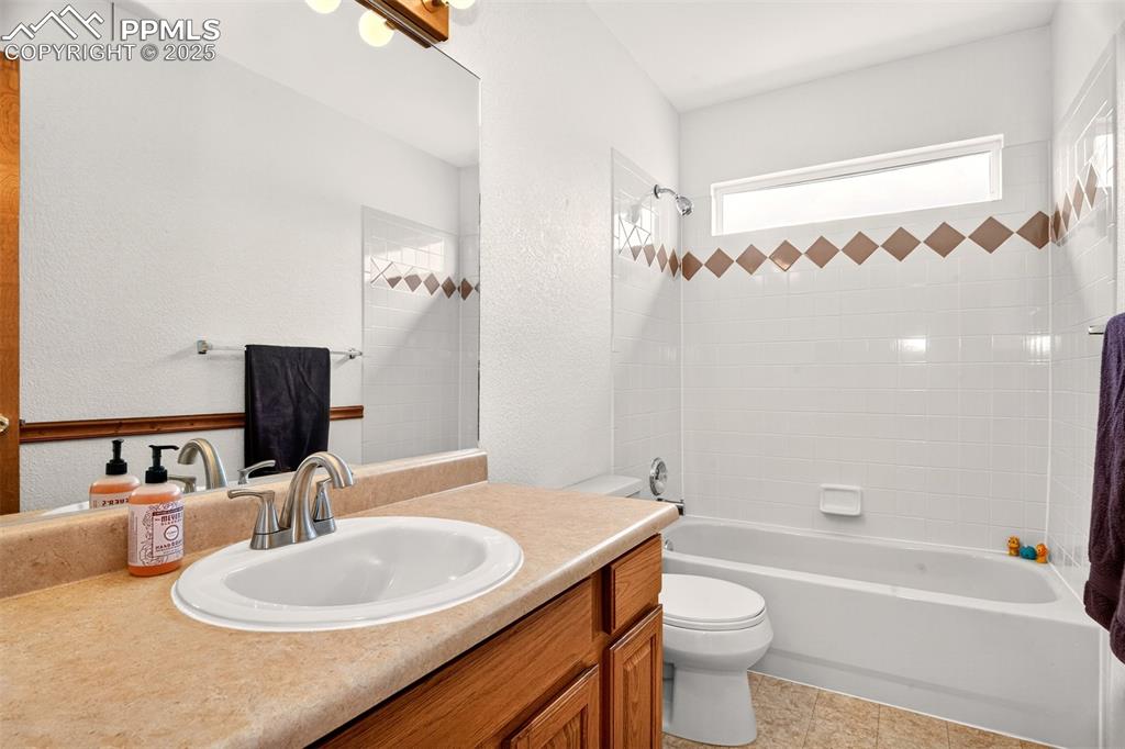 Image 23 of 40: Upper level Full Bathroom with shower/tub combination, a textured wall, v