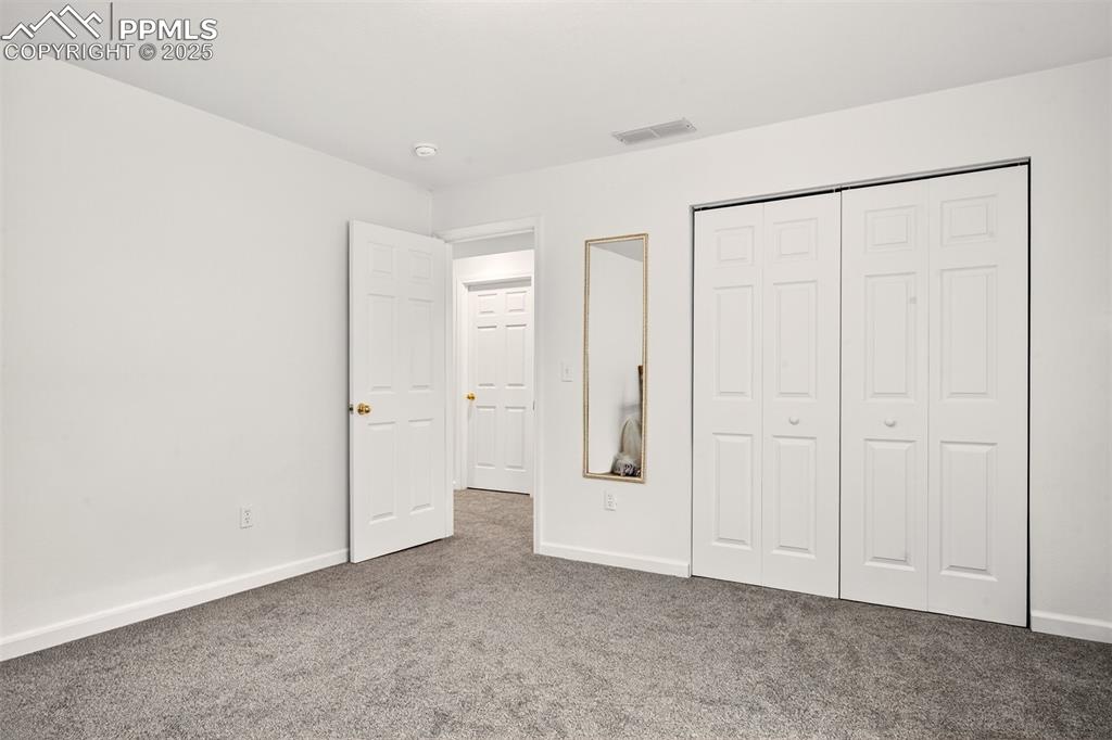 Image 27 of 40: Unfurnished bedroom with carpet flooring and a closet in the garden level b