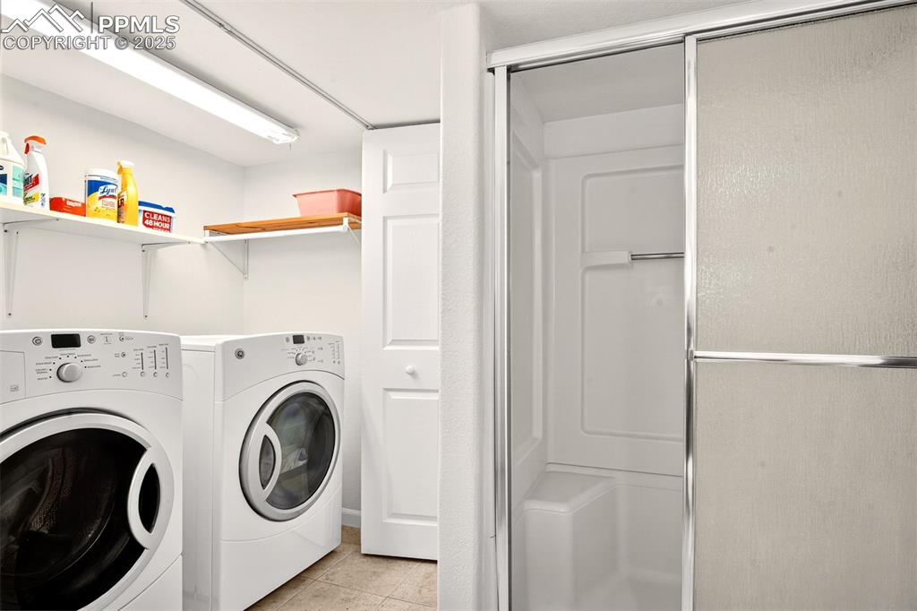 Image 29 of 40: Washroom featuring light tile patterned flooring and washer and dryer