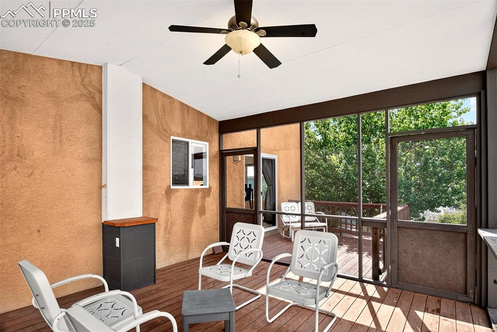 Image 34 of 40: Sunroom / solarium with a ceiling fan and a wooden deck