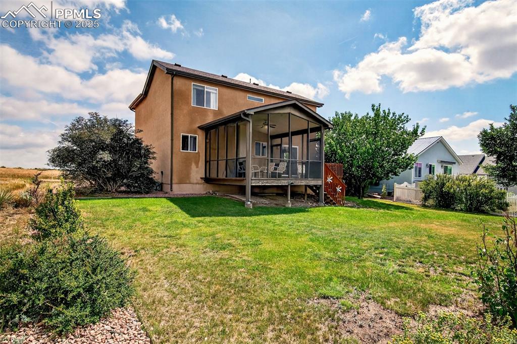 Image 36 of 40: Back of house featuring a sunroom, a deck, and stucco siding