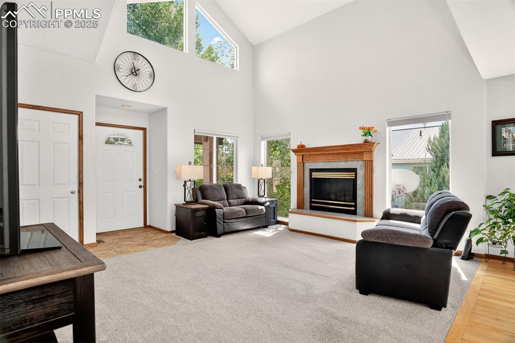Image 5 of 40: Living room with high vaulted ceiling, a high end gas fireplace, and light
